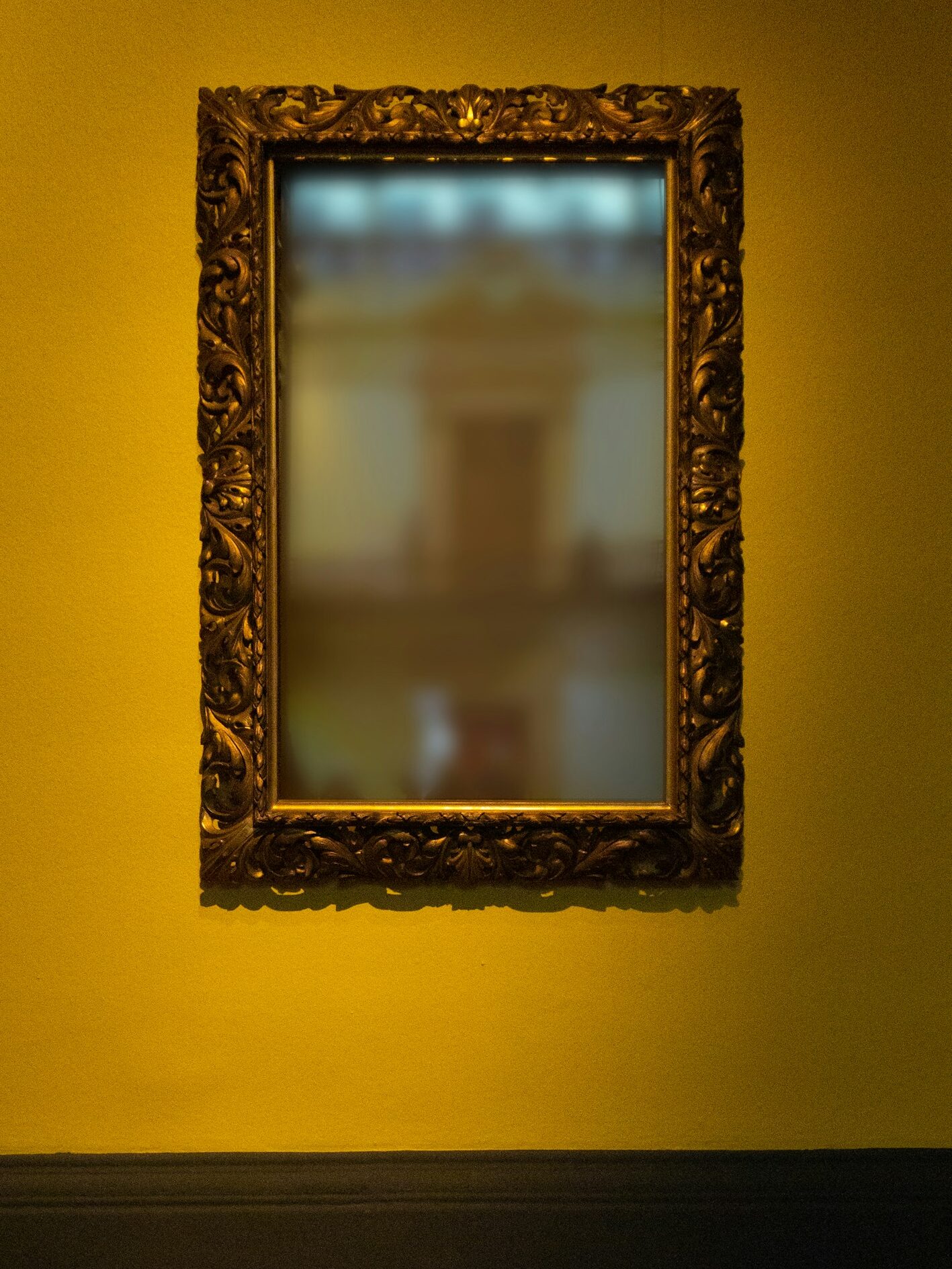 rectangular leaning mirror with brass-colored frame